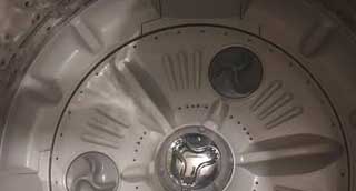 Technician checking a washing machine drainage problem